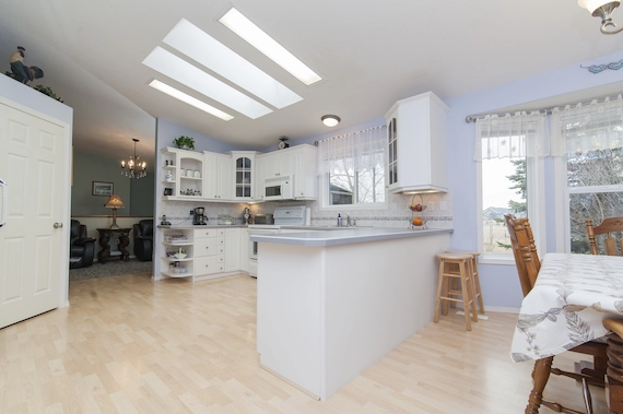 Bright kitchens and dining areas with light-colored tile flooring, white cabinets, and an open dining space.