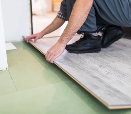 Professional installing laminate flooring as part of a Premium Laminate Flooring Installation.