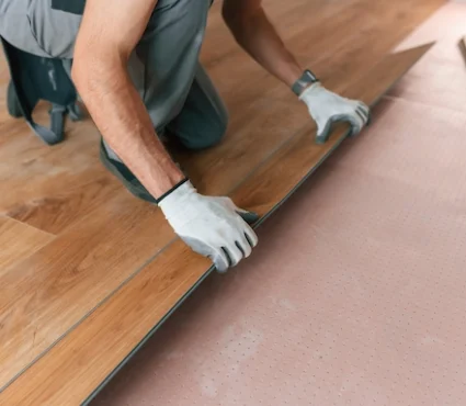 Professional Premium Wood Flooring Installation with a worker fitting wood floor planks.